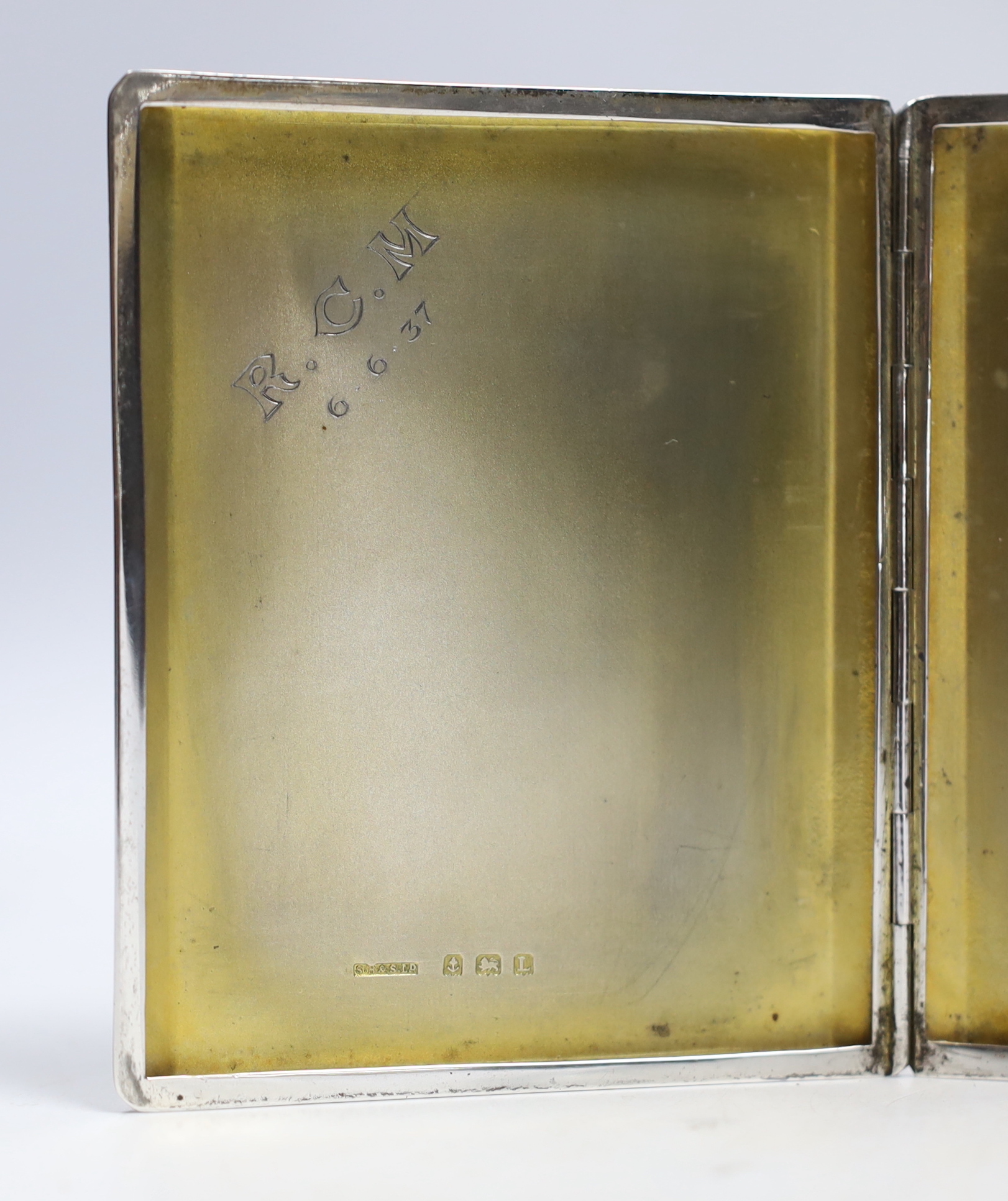 A George V engine turned silver cigarette case, Birmingham, 1935, 10.2cm and one other earlier silver cigarette case.